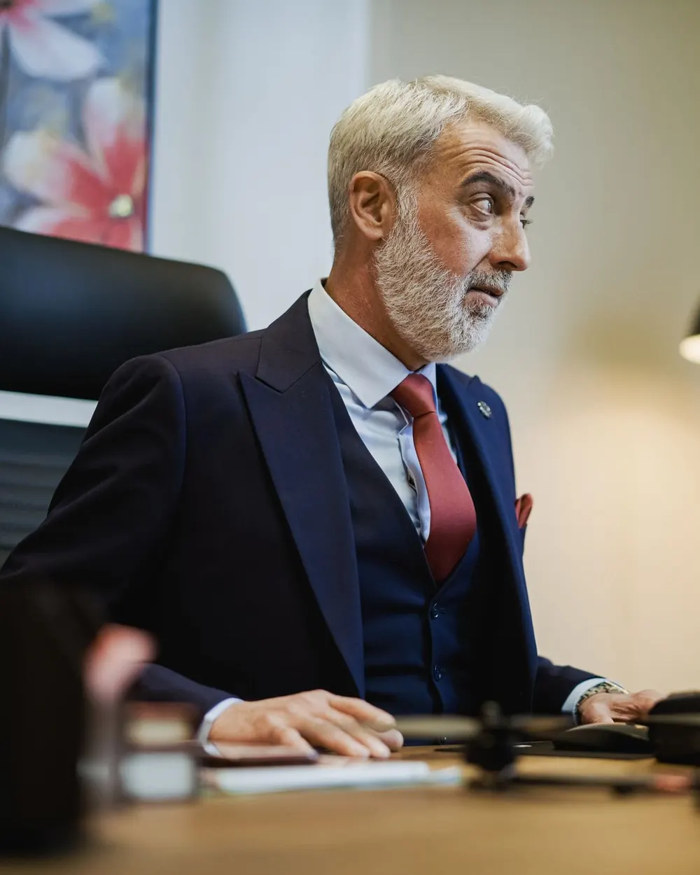 A senior executive at his desk in a warmly lit office