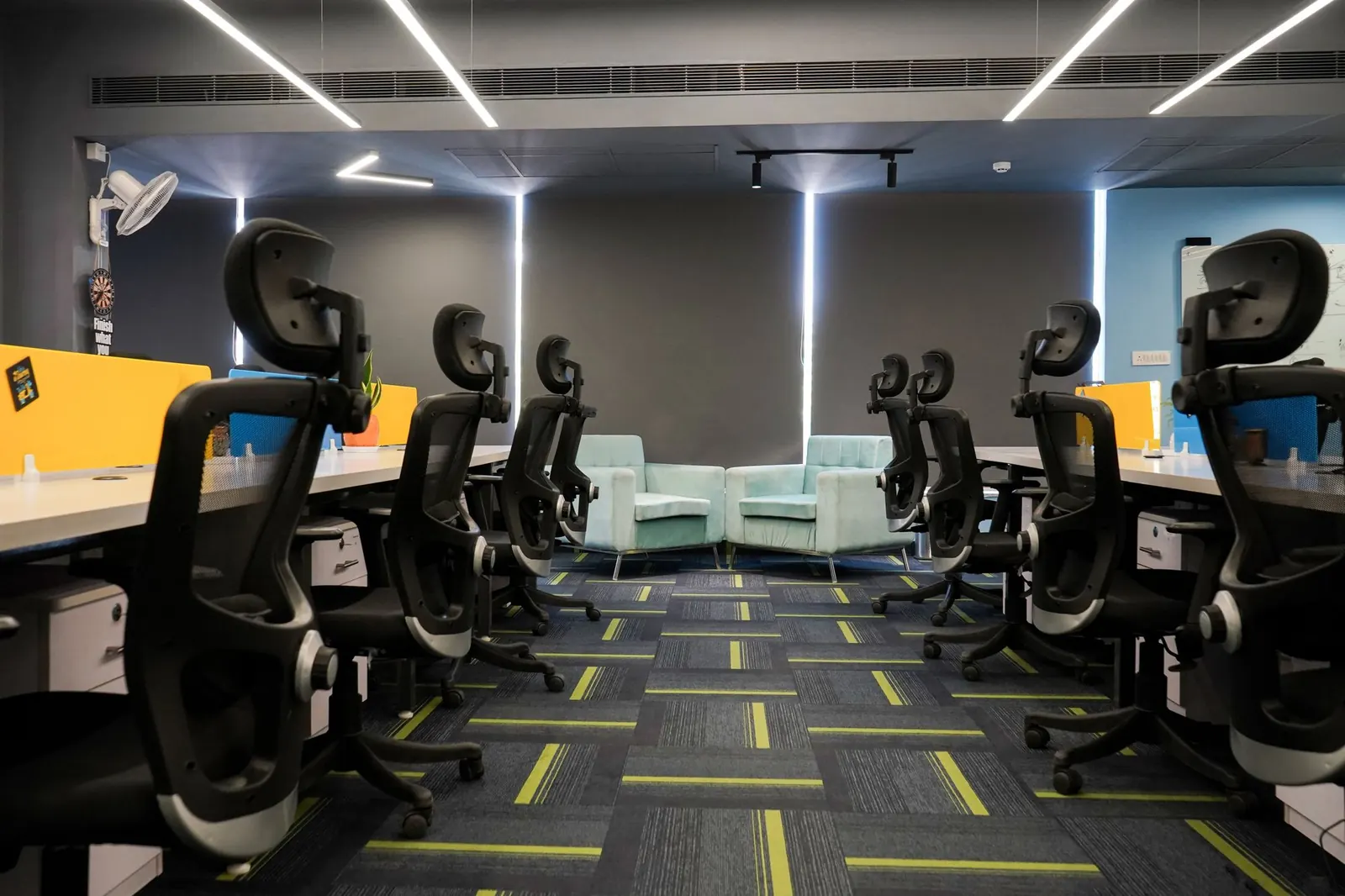 A modern open-plan office floor with rows of ergonomic chairs